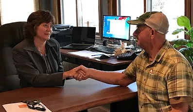 Wendy Fleener shaking hands with a client at her Windsor, CO office